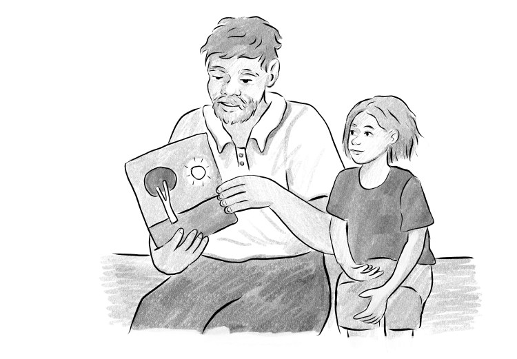 A grandfather talks about a picture book with his grandchild